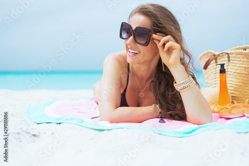 smiling 40 year old woman looking into distance and sun tanning