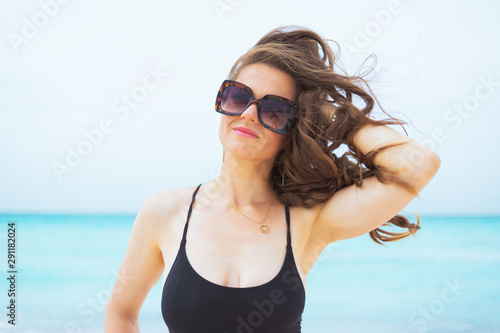 relaxed modern middle age woman on white beach