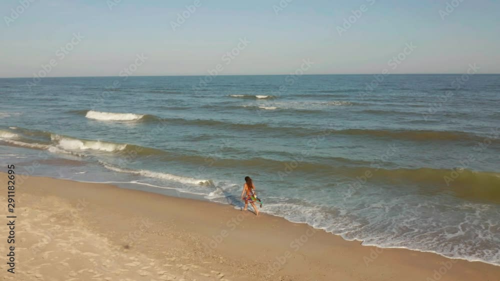 slim sporty woman is running alone in early morning on seacoast. slow motion slim sporty woman is running alone in early morning on seacoast. slow motion