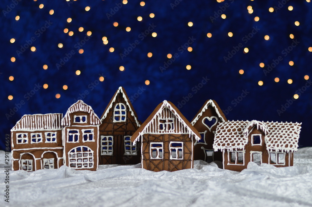 home made gingerbread town with bokeh sky out of blue velvet and christmas lights as advent decoration for the family