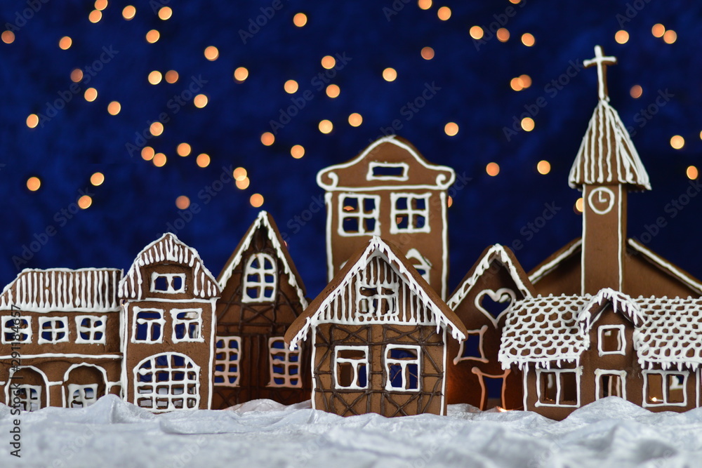 home made gingerbread town with church and bokeh sky out of blue velvet and christmas lights as advent decoration for the family
