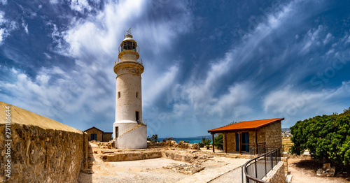Cyprus. Pathos. A white lighthouse against a dark sky. Attractions of Paphos. Lighthouse and caretaker's house on the Mediterranean coast. Travelling to Cyprus. photo