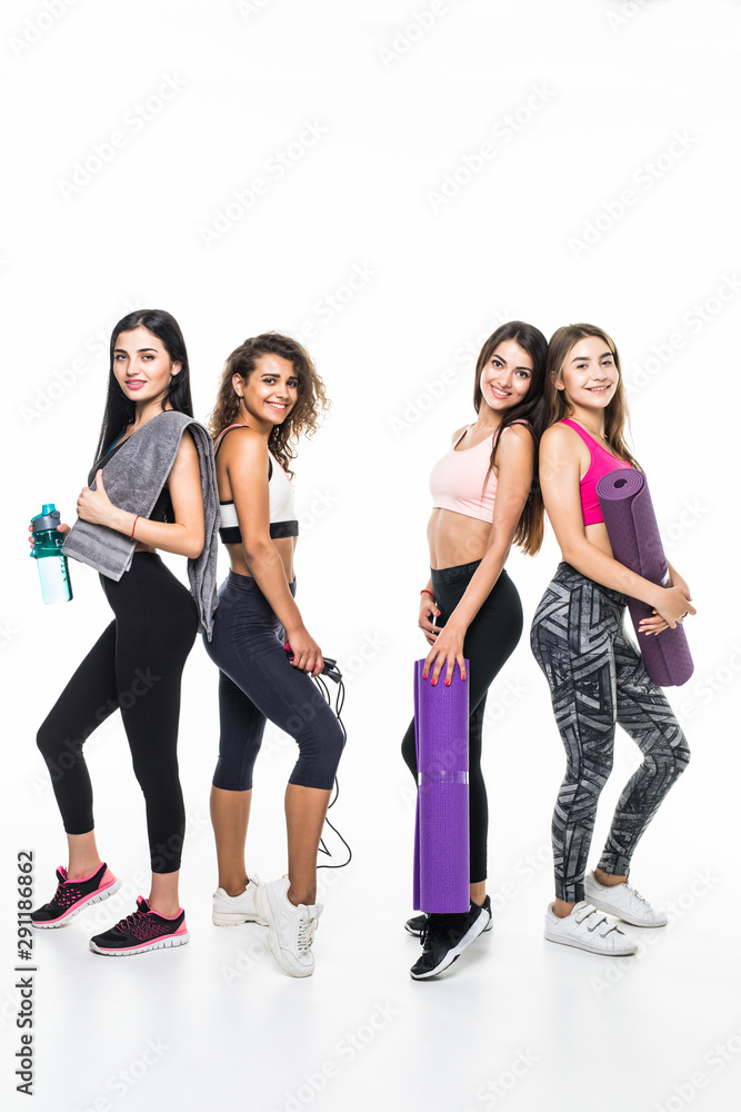 Fototapeta premium Four fitness girls in sportwear holding exercises equipment isolated on white background