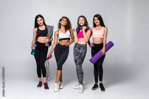 Four beauty women fitness holding different exercises equipment isolated on white background