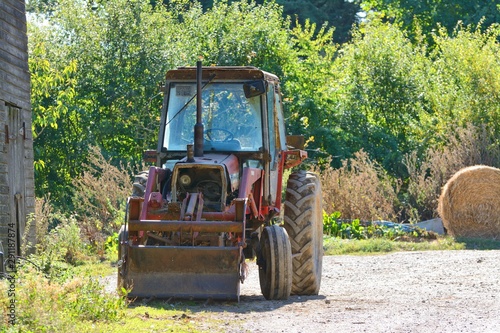 old tractor and haybale in farmyard