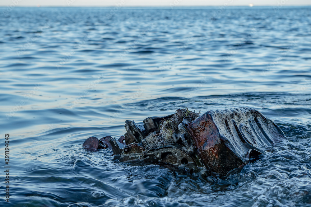 Old rusty engine lying among stones in the water. Old rusty engine lying among stones in the water.