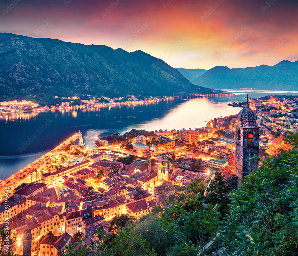 Dramatic summer sunset in Kotor port. Aerial evening view of Kotor bay and Old Town from hill of  Lovcen Mountain. Beautiful world of Mediterranean countries. Traveling concept background.