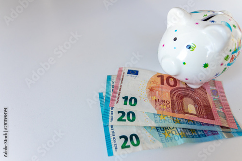 Weißes Sparschwein mit Aufschrift Happy Birthday und EURO-Geldscheinen 50 EUR, 20 EUR und 10 EUR steht für Geldgeschenke, Geburtstag, sparen, Einkommen, Bonus, Jubiläum, Ersparnis, Rabatt und Prämien