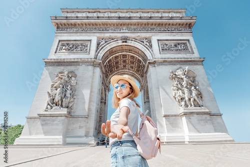 Happy Asian tourist girl enjoys the view of the majestic and famous Arc de Triomphe or Triumphal arch. Follow me and Travel to Paris and France © EdNurg