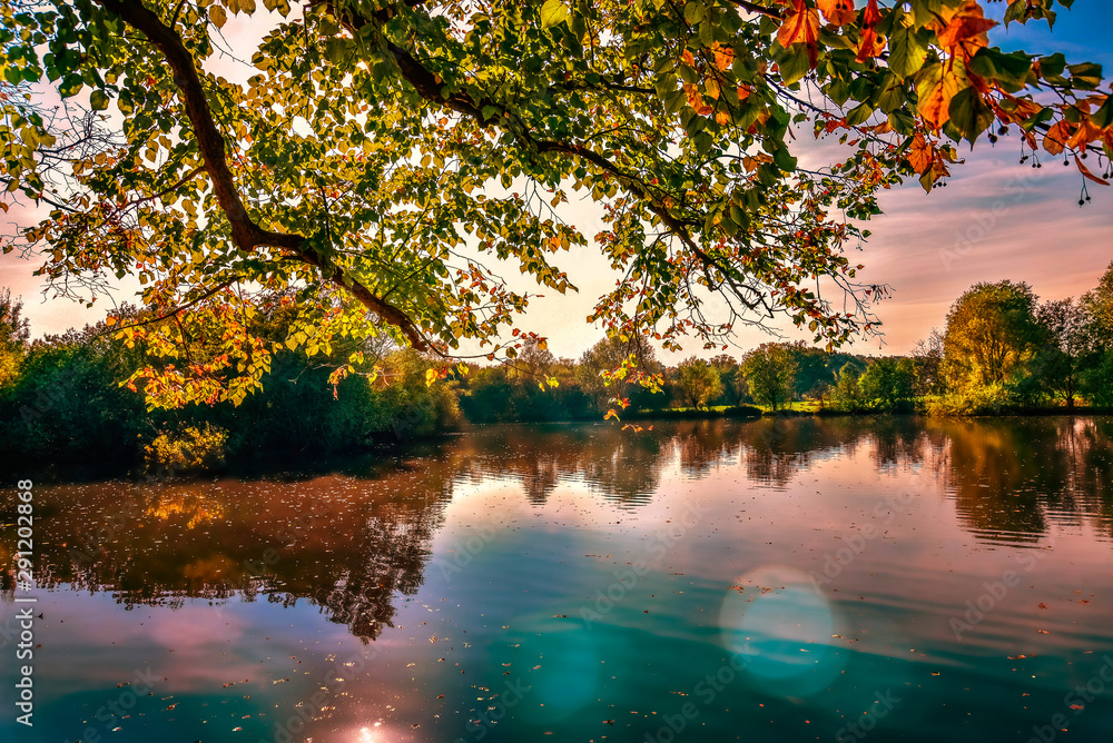 Fototapeta premium Autum Fall sunset colours warm outside lake water still smooth red blue dreaming