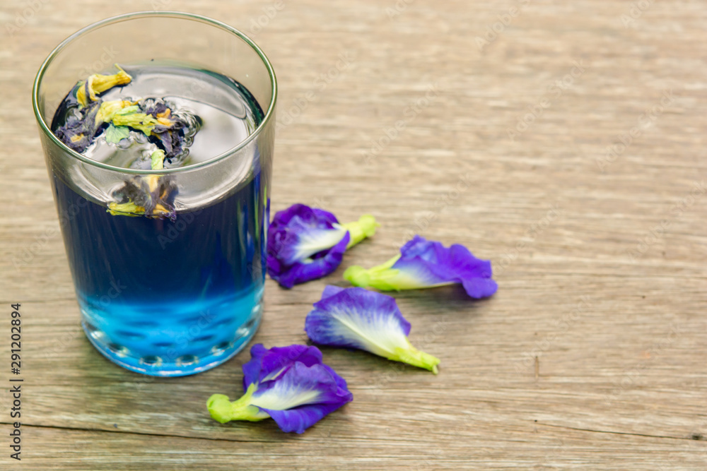 Butterfly pea juice and butterfly pea flower on wood background Butterfly pea juice and butterfly pea flower on wood background