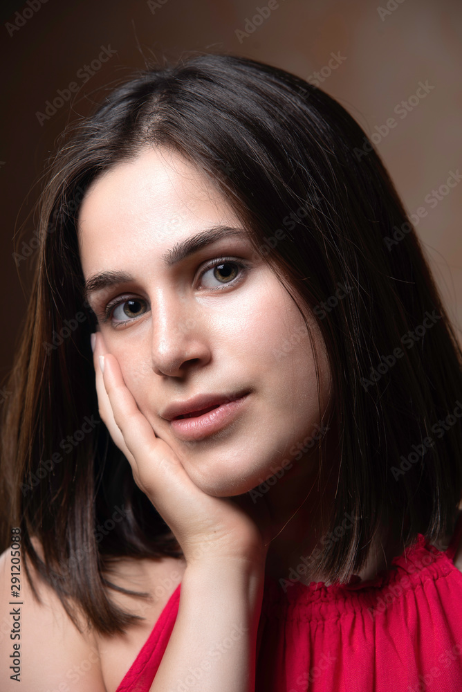 beautiful young brunette caucasian girl face portrait with her cute eyes looking at the camera, confident happy smile look with Hand on the cheek pose beautiful young brunette caucasian girl face portrait with her cute eyes looking at the camera, confident happy smile look with Hand on the cheek pose