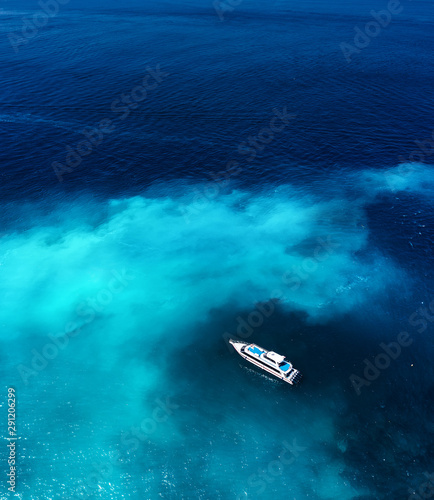 Fast boat at the sea in Bali, Indonesia. Aerial view of luxury floating boat on transparent blue water at sunny day. Summer seascape from air. Top view from drone. Travel - image © biletskiyevgeniy.com