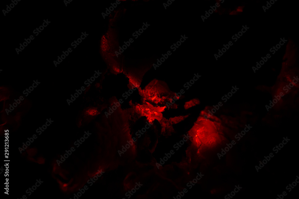Fototapeta premium The heat of smoldering charcoal in the dark.