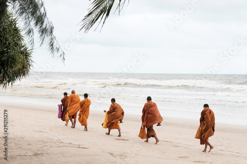 monks walking along the beach