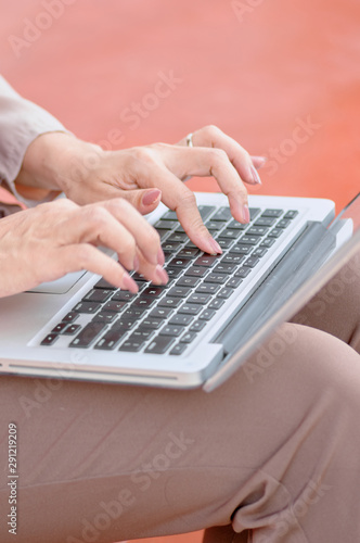 Woman typing on keyboard of computer laptop
