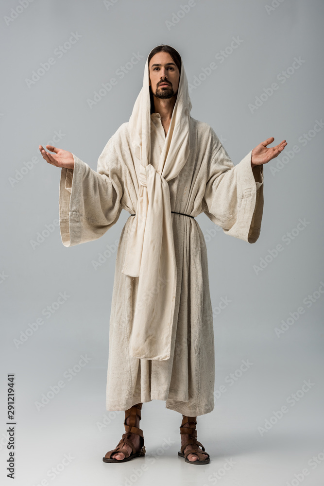 bearded man in hood standing with outstretched hands isolated on grey bearded man in hood standing with outstretched hands isolated on grey