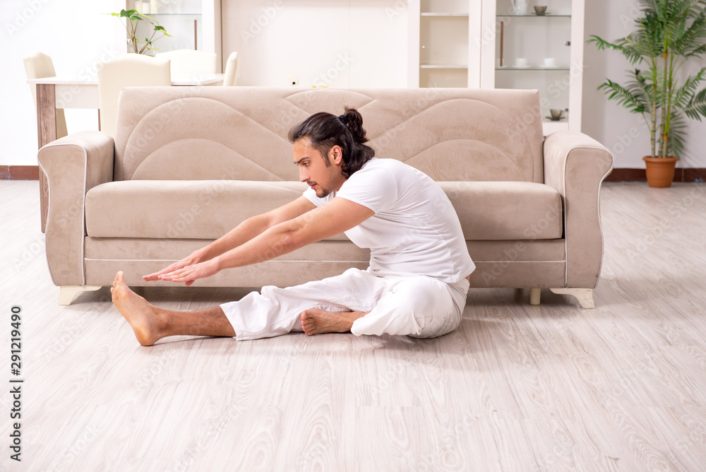 Young man doing physical exercises at home Young man doing physical exercises at home