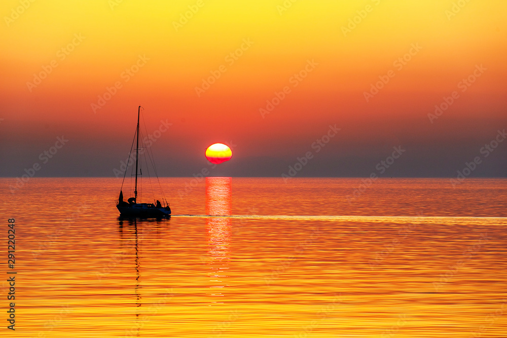 Sea yacht sailing against the backdrop of a picturesque sunset