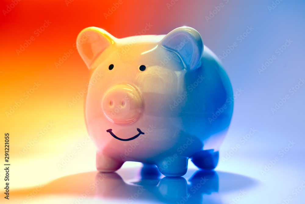Smiling Piggybank on red and blue background. Saving vs spending money concept.