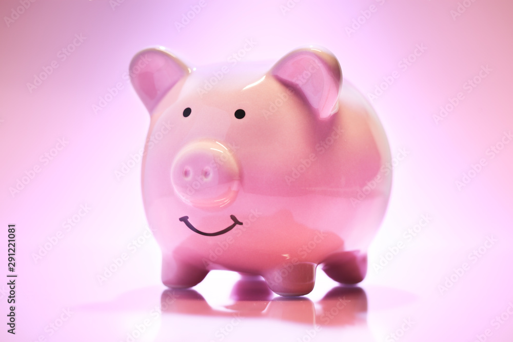 Smiling Piggybank on pink background. Saving money concept.