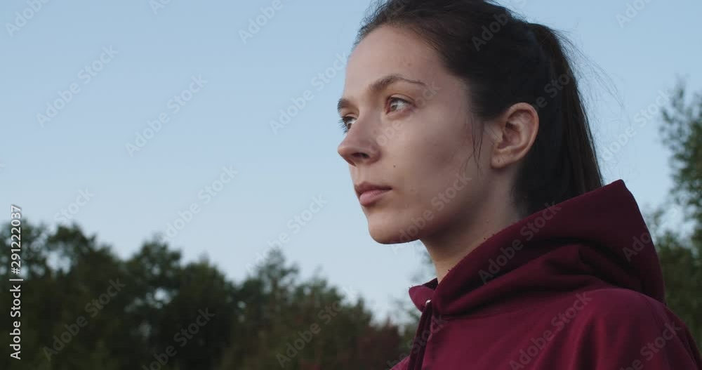 Female face close up looking aside outdoors nature country background. Portrait of young natural woman without make-up posing outside copy space. Skin hair care products idea inspiration concept Female face close up looking aside outdoors nature country background. Portrait of young natural woman without make-up posing outside copy space. Skin hair care products idea inspiration concept