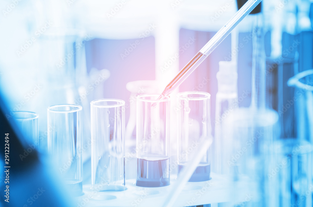 A pipette dropping sample into a test tube,abstract science background A pipette dropping sample into a test tube,abstract science background