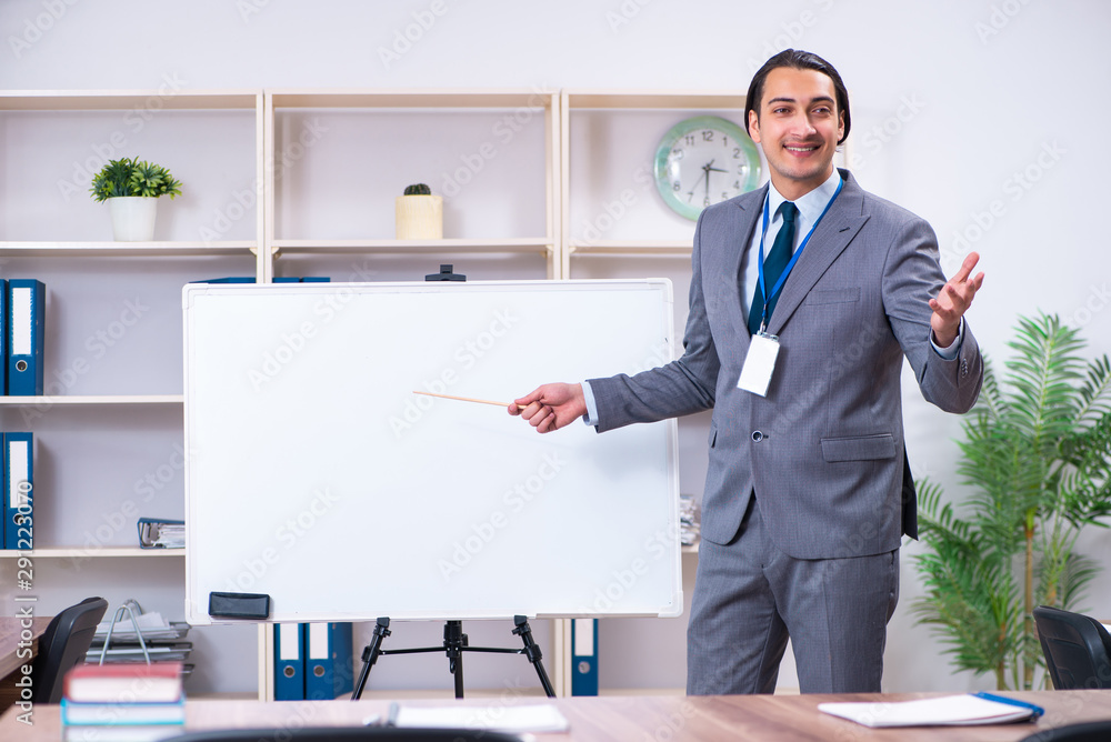 Young businessman standing in front of white board Young businessman standing in front of white board