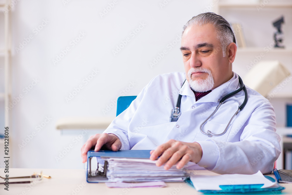 Old male doctor working in the clinic Old male doctor working in the clinic