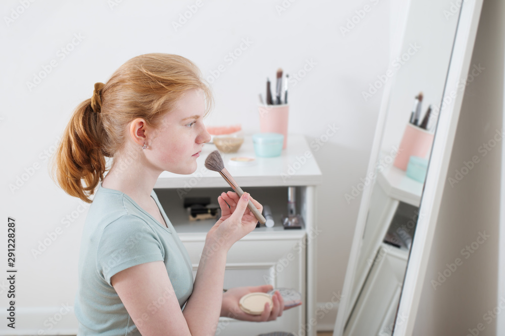 teen girl powders her face teen girl powders her face