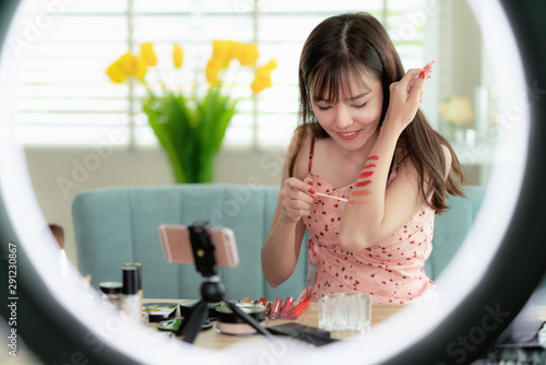 фотографія Asian girl teat lip color on her arm in her clip with donus light, this image ca