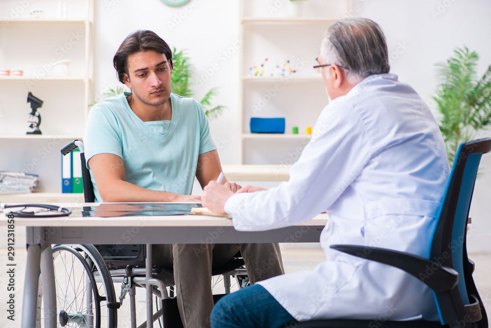 Obraz premium Male patient in wheel-chair visiting old doctor