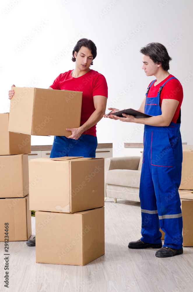Two young contractor employees moving personal belongings Two young contractor employees moving personal belongings
