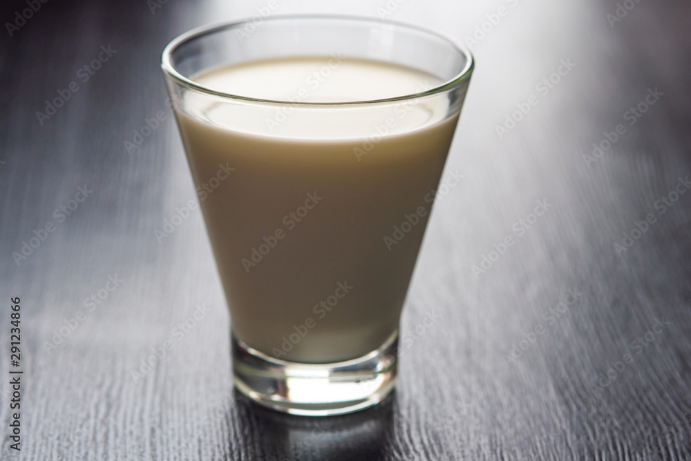Milk in a glass cup on a wooden background. Milk in a glass cup on a wooden background.