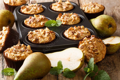 Dietary delicious pear muffins with walnuts and oatmeal in a baking dish close-up. horizontal