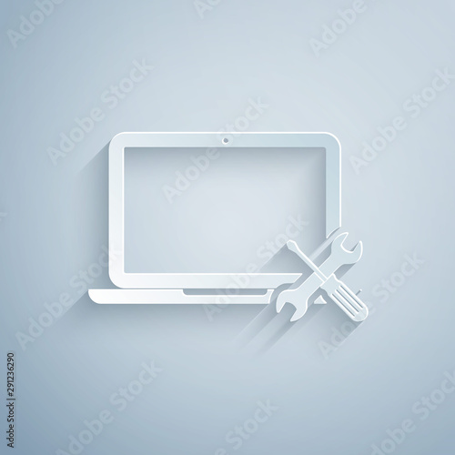 Paper cut Laptop with screwdriver and wrench icon isolated on grey background. Adjusting, service, setting, maintenance, repair, fixing. Paper art style. Vector Illustration