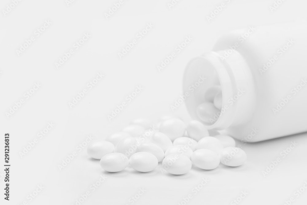 Pill bottle spilling medical pills onto surface isolated on a white background. Pill bottle spilling medical pills onto surface isolated on a white background.