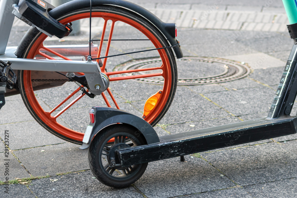 Leihfahrrad eines Bike-Sharing-Anbieters und E-Scooter stehen nebeneinander und repräsentieren emissionsfreie Beförderung und Fortbewegung in der Stadt als Alternative zum Auto Leihfahrrad eines Bike-Sharing-Anbieters und E-Scooter stehen nebeneinander und repräsentieren emissionsfreie Beförderung und Fortbewegung in der Stadt als Alternative zum Auto