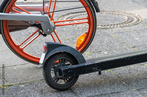 Leihfahrrad eines Bike-Sharing-Anbieters und E-Scooter stehen nebeneinander und repräsentieren emissionsfreie Beförderung und Fortbewegung in der Stadt als Alternative zum Auto photo