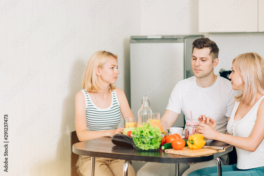 Friends sitting at table in kitchen Friends sitting at table in kitchen