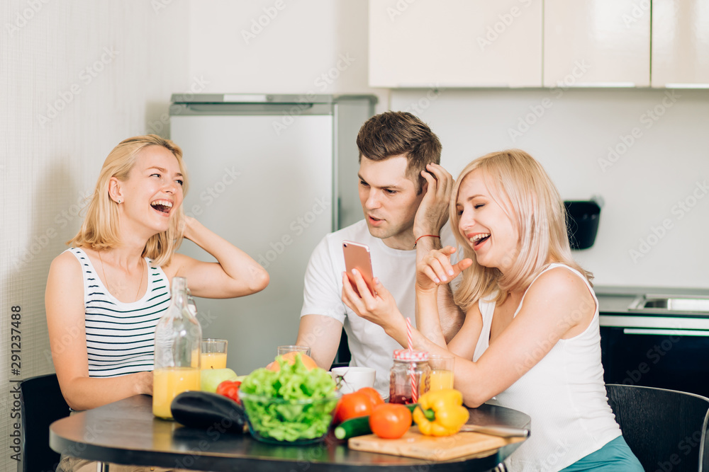 Friends sitting at table in kitchen Friends sitting at table in kitchen