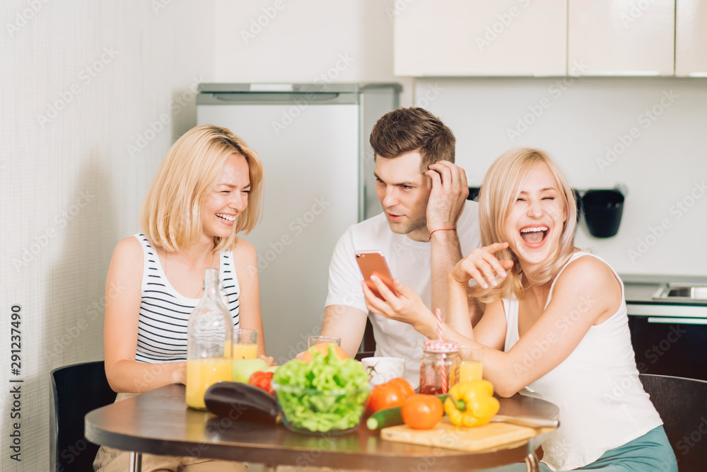 Friends sitting at table in kitchen Friends sitting at table in kitchen