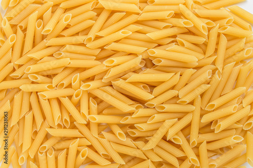 Large group of penne Italian pasta ready to be cooked, displayed as background with top view