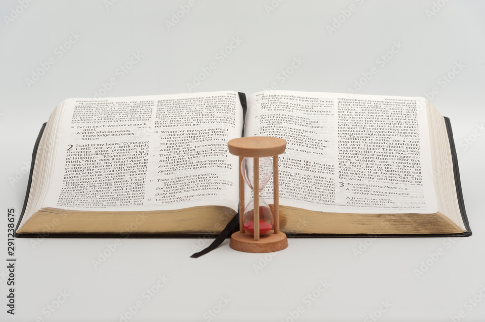Holy Bible (Word of GOD) opened in Ecclesiastes 2 and 3 with hourglass ...