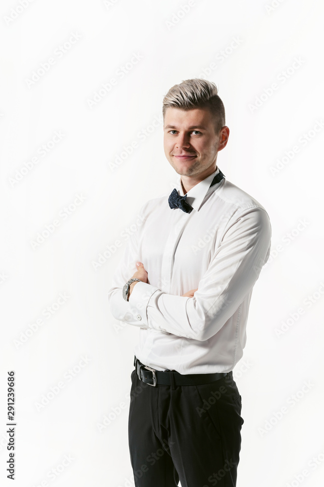 Portrait of young smiling handsome showman in white shirt with bowtie, studio shot isolated on white background. Businessman Portrait of young smiling handsome showman in white shirt with bowtie, studio shot isolated on white background. Businessman