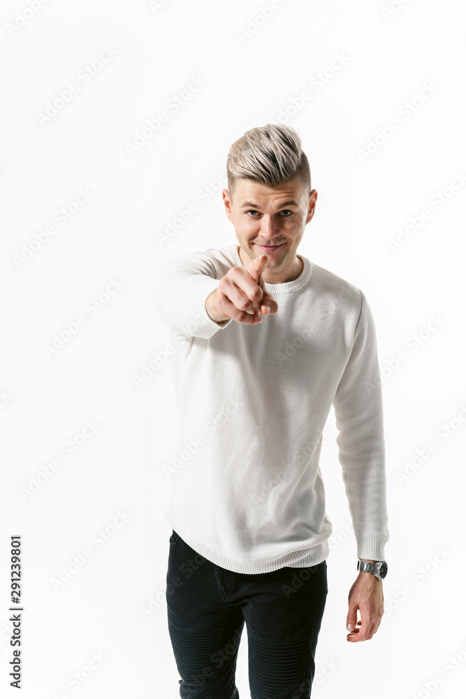 Portrait of handsome male student man looking at camera and shows a finger over white background and showing emotions Portrait of handsome male student man looking at camera and shows a finger over white background and showing emotions