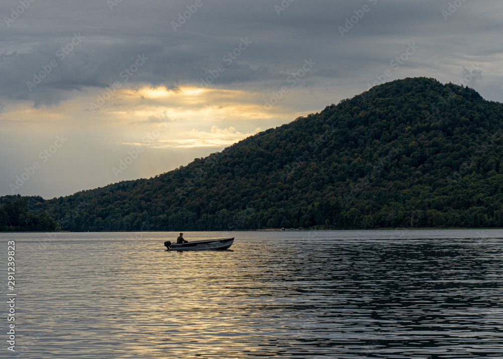 A fisherman in the lake at sunset A fisherman in the lake at sunset