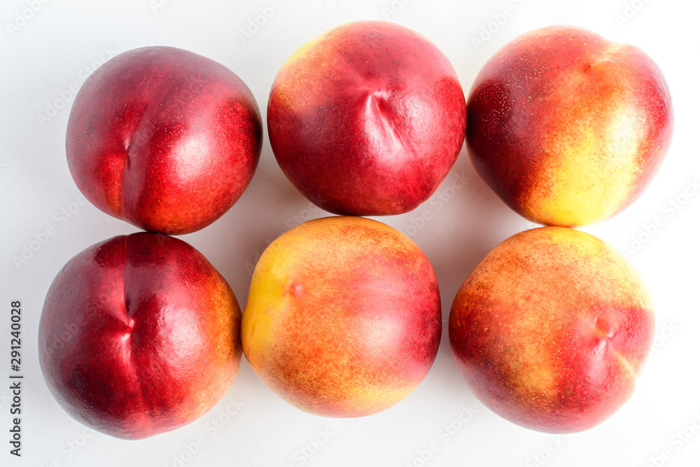 Six fresh ripe nectarine fruits displated as on two lines on a white table, isolated on white, with soft focus, top view Six fresh ripe nectarine fruits displated as on two lines on a white table, isolated on white, with soft focus, top view