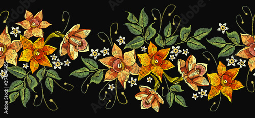 Embroidery narcissuses horizontal seamless pattern. Template for clothes, textiles, t-shirt design. Beautiful spring daffodils on black background