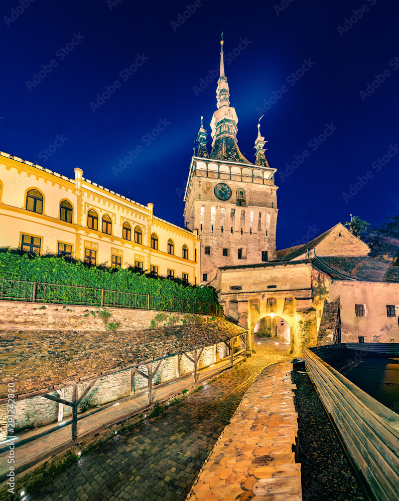 Attractive evening view of famous medieval fortified city and the Clock Tower built by Saxons. Fantastic summer cityscape of Sighisoara, Transylvania, Romania, Europe. Traveling concept background.